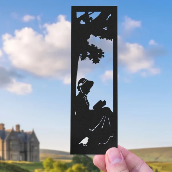 Marcapáginas troquelado de Jane Austen en polipropileno negro mate con silueta leyendo bajo un árbol.